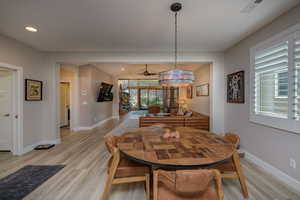 Dining area with ceiling fan and light hardwood / wood-style flooring