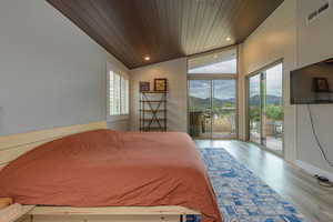 Bedroom featuring lofted ceiling, light hardwood / wood-style floors, access to exterior, and wood ceiling