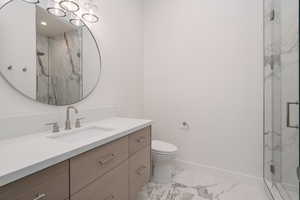 Bathroom featuring marble look tiles, vanity, and a marble finish shower