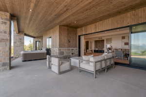 View of patio / terrace with a hot tub and an outdoor living space