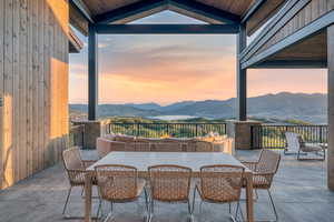 Patio terrace at dusk featuring a mountain view, outdoor dining area, and a patio area