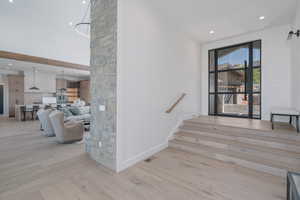 Staircase with wood finished floors, a high ceiling, and recessed lighting