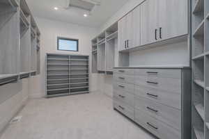 Spacious closet with light colored carpet and attic access