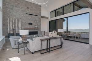 Living room featuring wood finished floors, a fireplace, and high vaulted ceiling