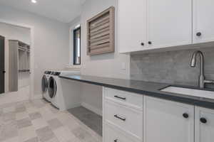 Laundry area with cabinet space, washing machine and dryer, and recessed lighting