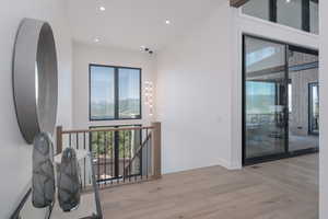 Corridor featuring wood finished floors, recessed lighting, and an upstairs landing
