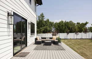 Wooden terrace featuring an outdoor living space and a yard