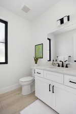 Bathroom with vanity, wood-type flooring, and toilet