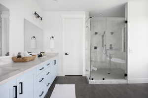 Bathroom featuring tile patterned flooring, vanity, and an enclosed shower