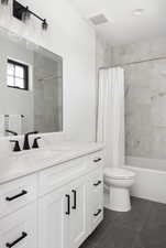 Full bathroom featuring tile patterned flooring, vanity, toilet, and shower / bath combo