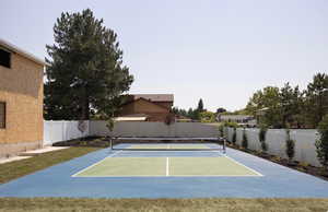 View of tennis court featuring basketball hoop