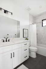 Full bathroom featuring tile patterned floors, vanity, toilet, and shower / bathtub combination with curtain