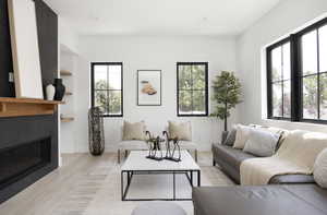 Living room featuring a tiled fireplace and light hardwood / wood-style flooring