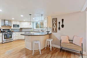 Kitchen featuring granite peninsula, stainless steel appliances to include a gas stove