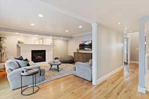 Living room with gas fireplace, hardwood floors, sliding glass doors to patio and ornamental molding