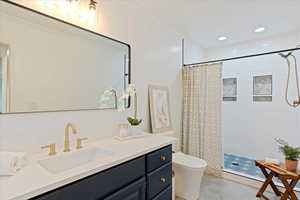 Primary bathroom with quartz counter tops and modern tiled shower and flooring