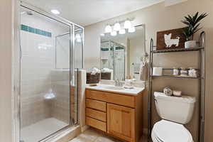 Single vanity bathroom with neutral tile patterned throughout