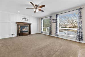 Unfurnished living room with ceiling fan and light carpet