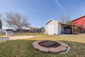 View of yard featuring a fire pit and a storage shed