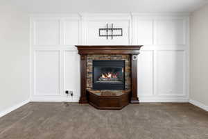 Room details with carpet flooring and a stone fireplace