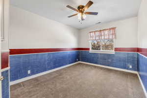 Unfurnished room with ceiling fan and carpet