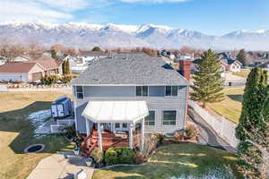 Rear view of property with a deck with mountain view and a yard