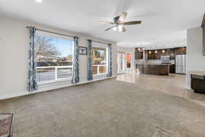 Unfurnished living room featuring ceiling fan and light tile patterned flooring