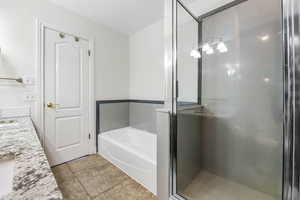 Bathroom featuring tile patterned flooring, vanity, and independent shower and bath