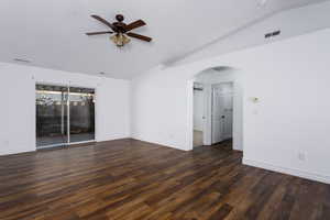 Unfurnished room with ceiling fan, lofted ceiling, and dark wood-type flooring