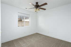 Spare room with ceiling fan and carpet floors