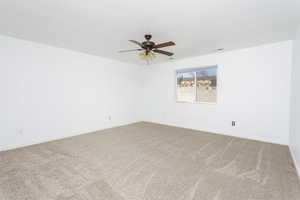 Carpeted empty room with ceiling fan