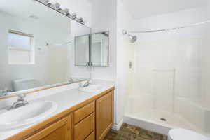 Bathroom featuring vanity, toilet, and walk in shower