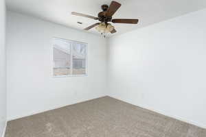 Unfurnished room featuring carpet and ceiling fan