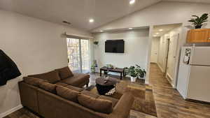 Living room with dark wood-type flooring and vaulted ceiling