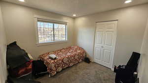 Carpeted bedroom with a textured ceiling