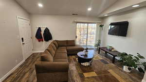 Living room featuring dark hardwood / wood-style flooring and vaulted ceiling