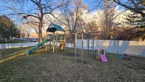 View of jungle gym with a lawn