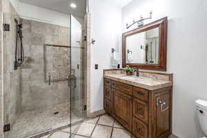 Bathroom featuring vanity, toilet, and an enclosed shower