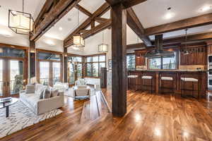 Living room featuring a wealth of natural light, french doors, high vaulted ceiling, and hardwood / wood-style floors