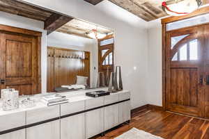 Interior space with beamed ceiling, wood ceiling, and dark hardwood / wood-style floors