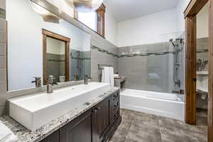 Full bathroom featuring tile patterned floors, toilet, vanity, tile walls, and tiled shower / bath