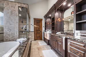 Bathroom featuring tile patterned floors, vanity, and shower with separate bathtub