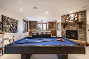 Game room featuring a fireplace, bar, and billiards