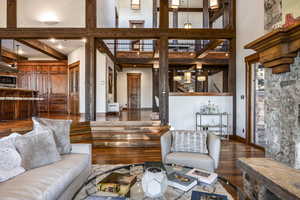 Living room with beam ceiling, a high ceiling, and dark hardwood / wood-style floors