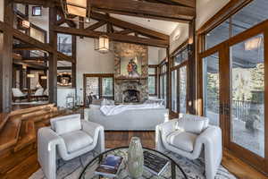 Living room with hardwood / wood-style flooring, a fireplace, high vaulted ceiling, and french doors