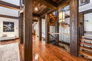 Hallway with beam ceiling, hardwood / wood-style flooring, and wood ceiling