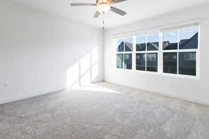 Carpeted spare room with ceiling fan