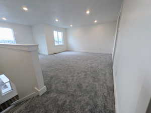 Spare room with dark colored carpet