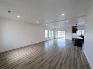 Unfurnished living room featuring dark wood-type flooring