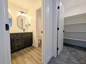 Bathroom featuring wood-type flooring, vanity, and toilet